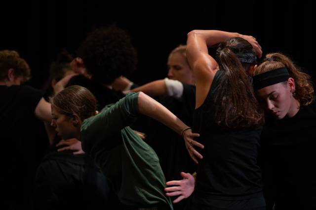 Group of 6 dancers with bodies and arms intertwined