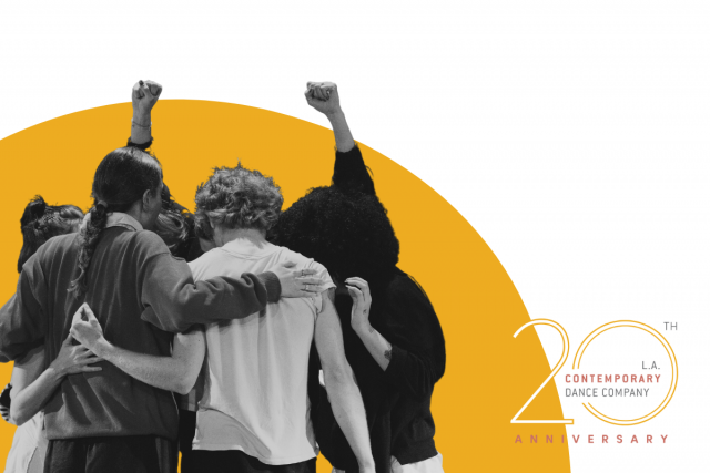 group of people huddle in a hug as one of them pumps their fists in the air. in the background, is a yellow graphic half circle similar to a sunrise