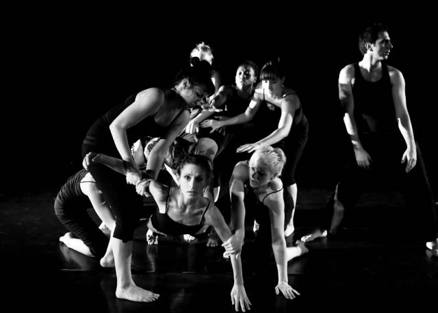 a mob of figures with one figure emerging from the group