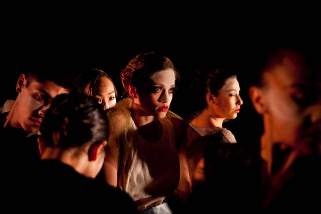 a woman stands in the middle of a group of people