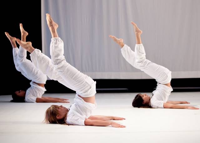 three woman lay on the floor with their legs raised to the sky