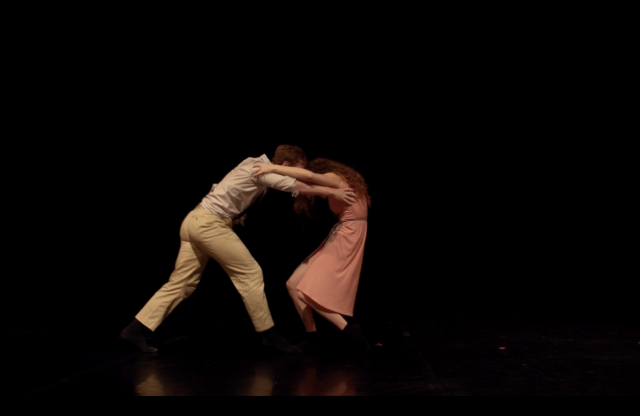 a man and woman face off, their arms on each other's shoulders