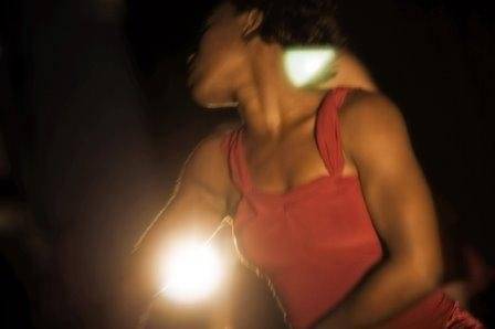 a woman captured in motion & wearing a maroon dress 