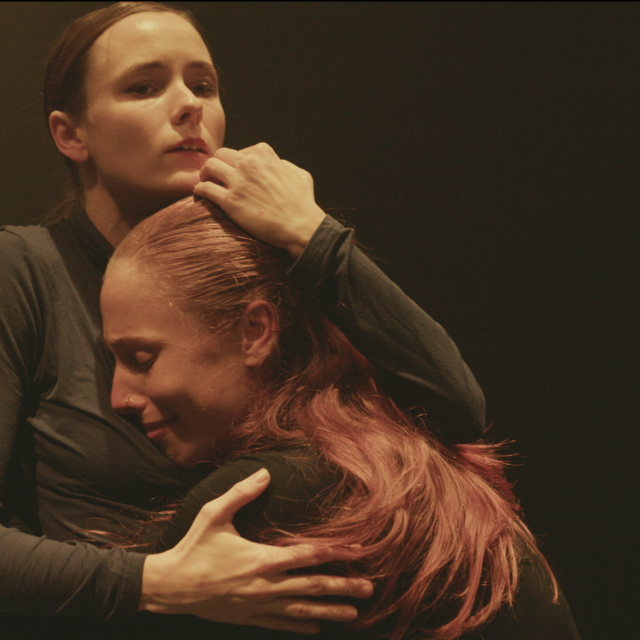 a woman embraces another woman on her chest