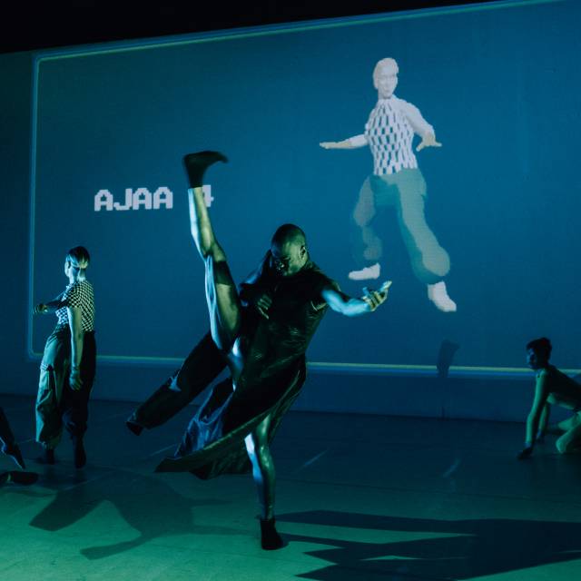 a brown skinned figure with his leg kicked high in the air