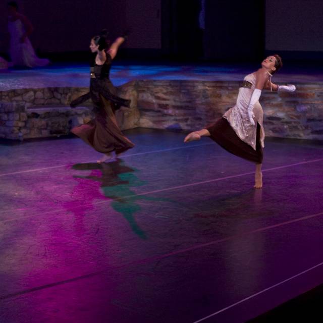 two wmen dance with arms and legs outstretched
