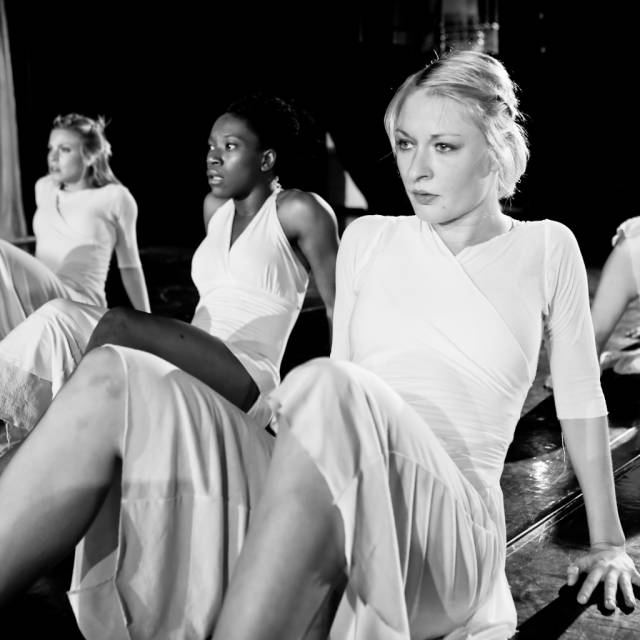 several women on the floor looking into the distance with fear in their eyes