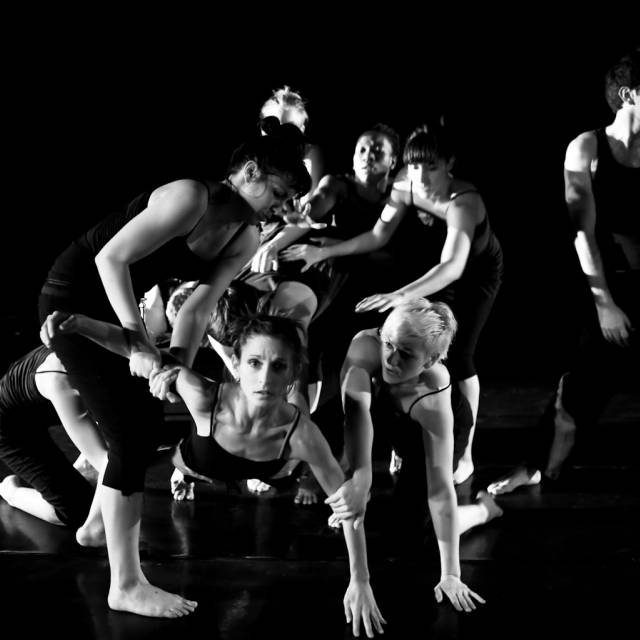 a mob of figures with one figure emerging from the group