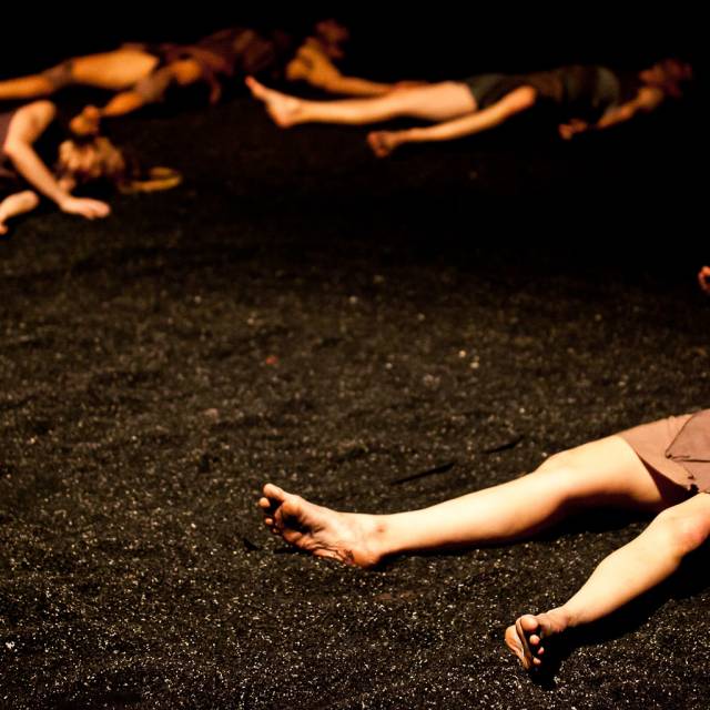 bodies laying in black sand