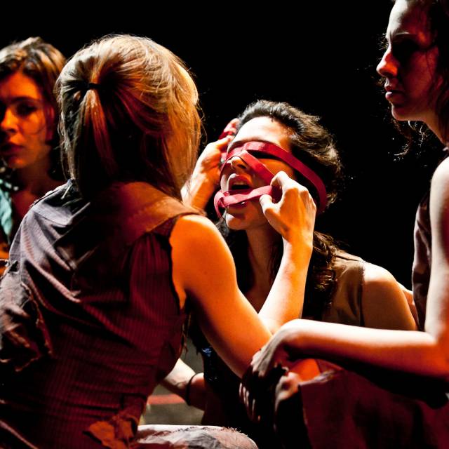 a red ribbon is wrapped around a woman's face and mouth