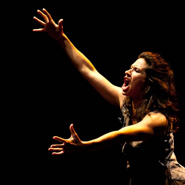 a woman yells with her arms outstretched