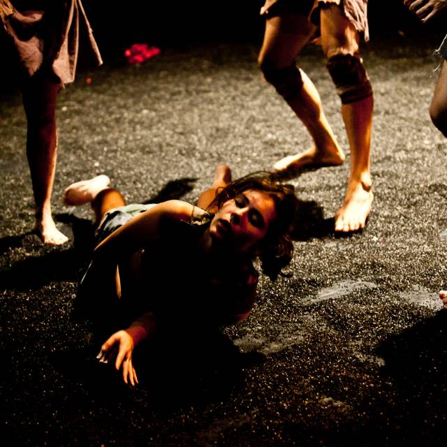 a woman crawls in black sand