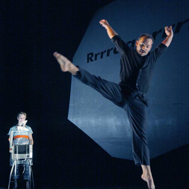 a fair skinned man jumping while a fair skinned woman watches