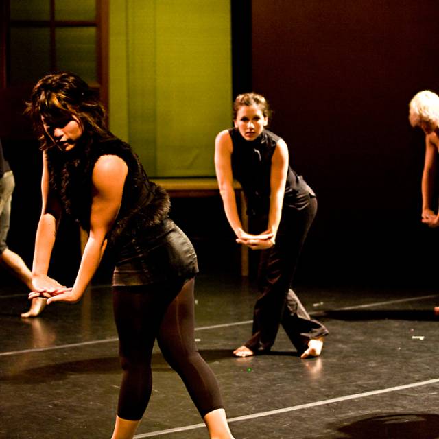 5 dancers of various skinned tones pose with their hands clasped