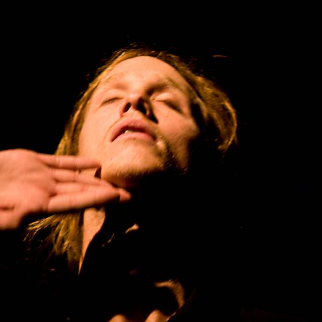 fair skinned man lifts his head to the sky with his eyes closed