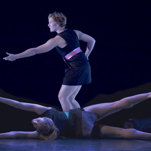 a fair skinned woman on the ground stretching all her limbs outward. a fair skinned woman stands with her arms outstretched.