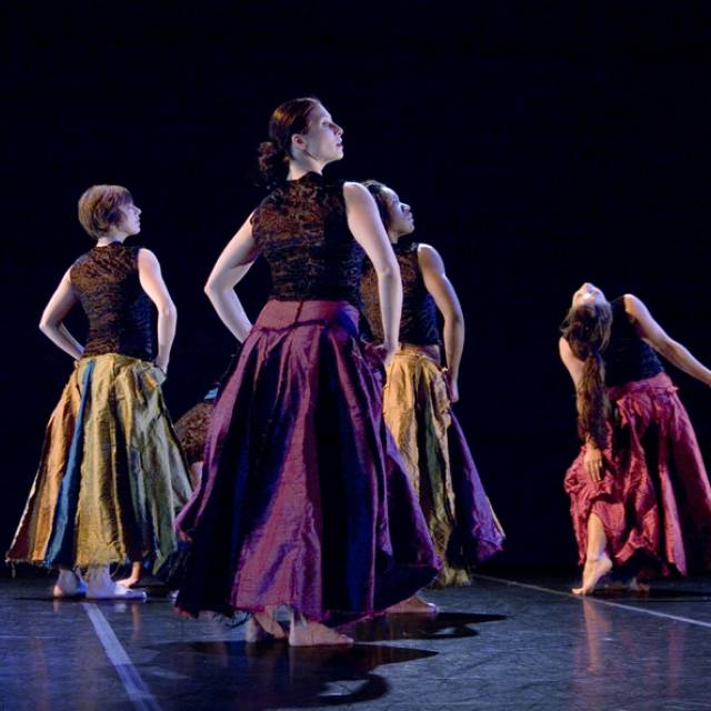 a group of women grab their long skirts