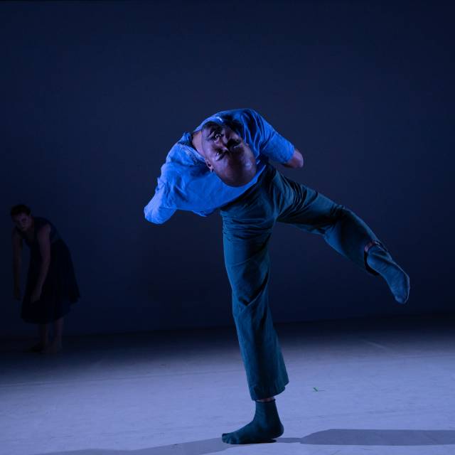 man balances on one leg while leaning back