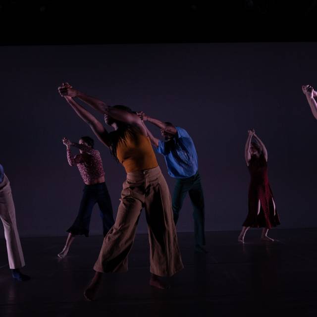 a group of people stretch their clasped hands outward