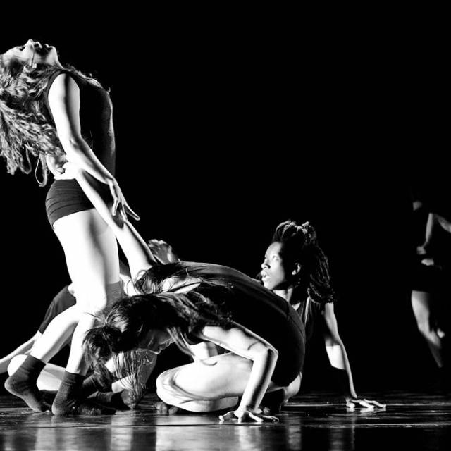 a woman throws her head back while another woman observes