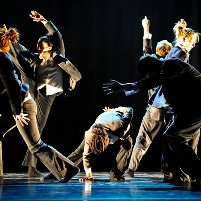 6 people in various poses wearing suits