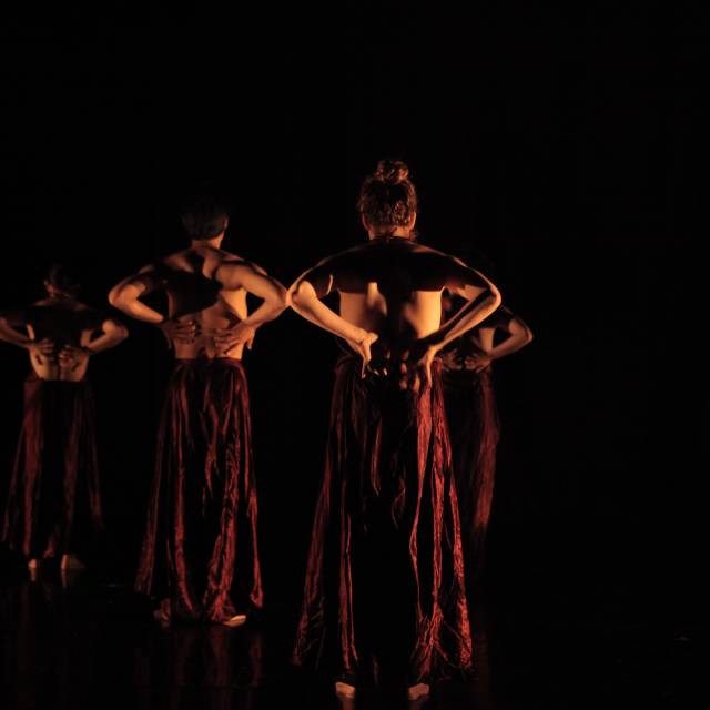 figures stand with their bare backs to us and the hands behind their backs