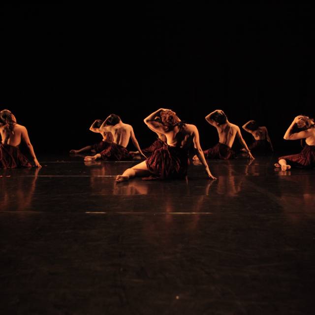 group of people with their bare backs facing us pull their head to the left