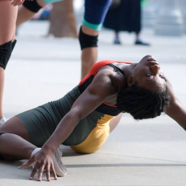 a woman on the ground lays back, looking behind her