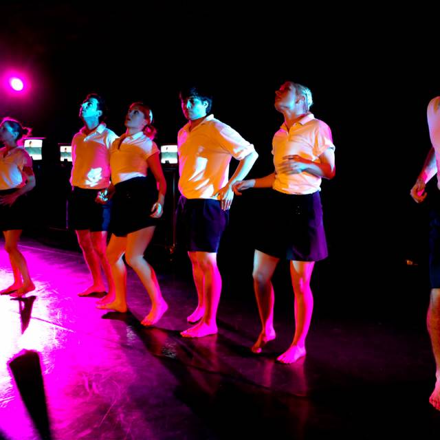 a group of people span the stage in awkward poses
