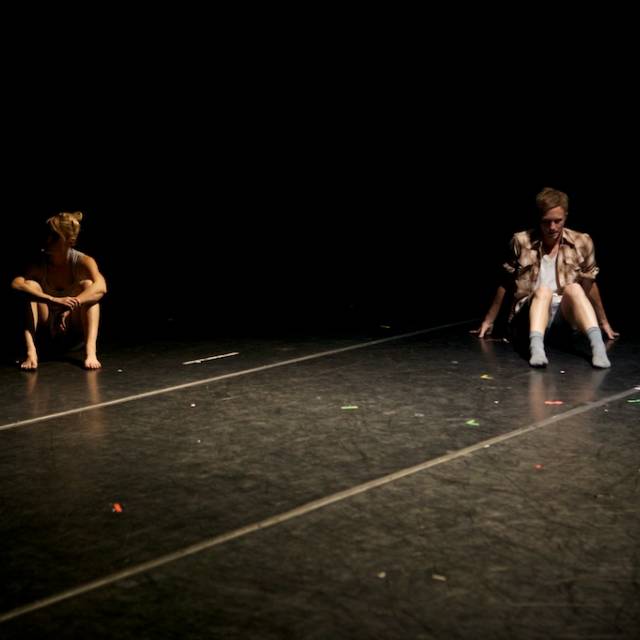 a man and woman sit on the floor far apart from each other