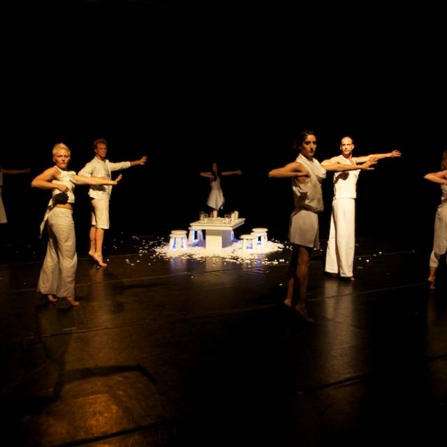 a group of people wearing with a white dinner table on top of styrofoam at their center