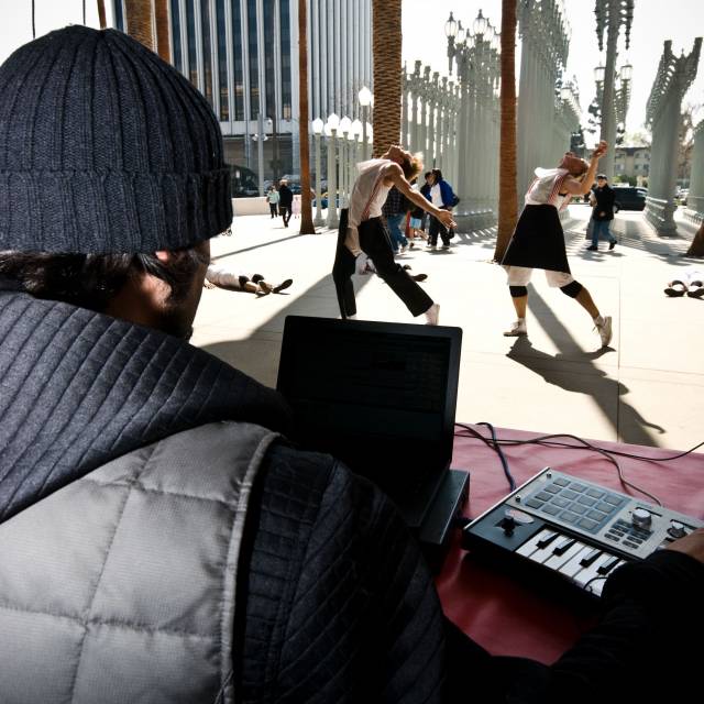 looking over the shoulder of a man with a keyboard to two people with their own thrown behind them