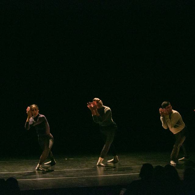 five dancers lunge with their hands cupping their faces