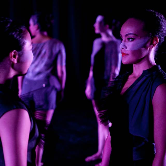 two women stand in front of one another, a strip of makeup spans across the middle of their faces