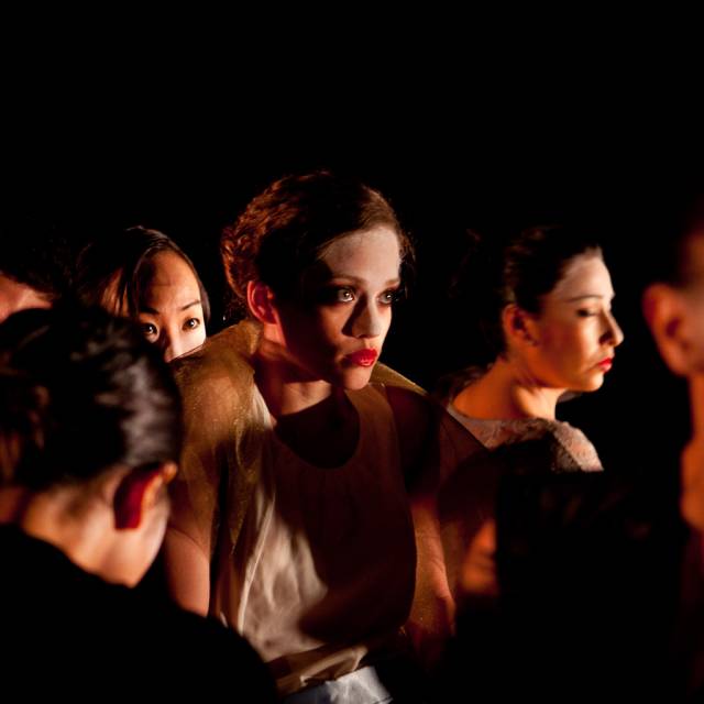 a woman stands in the middle of a group of people