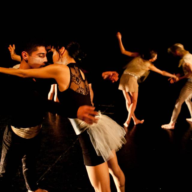 pairs of dancers face off with their arms stretched toward one another