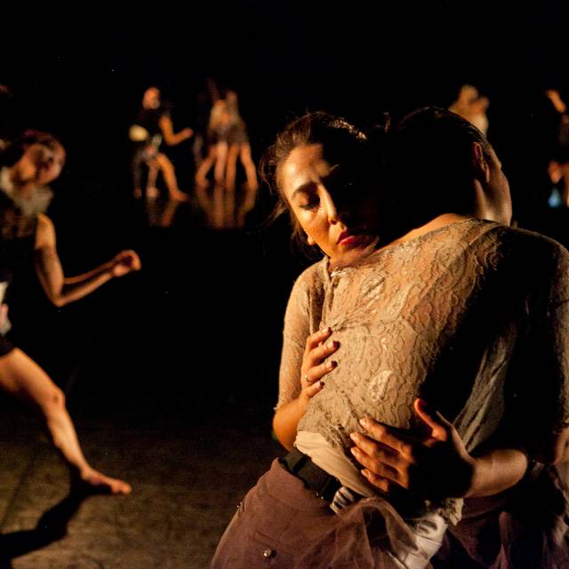 pairs of dancers in mid-motion. the pair of women in the foreground embrace.
