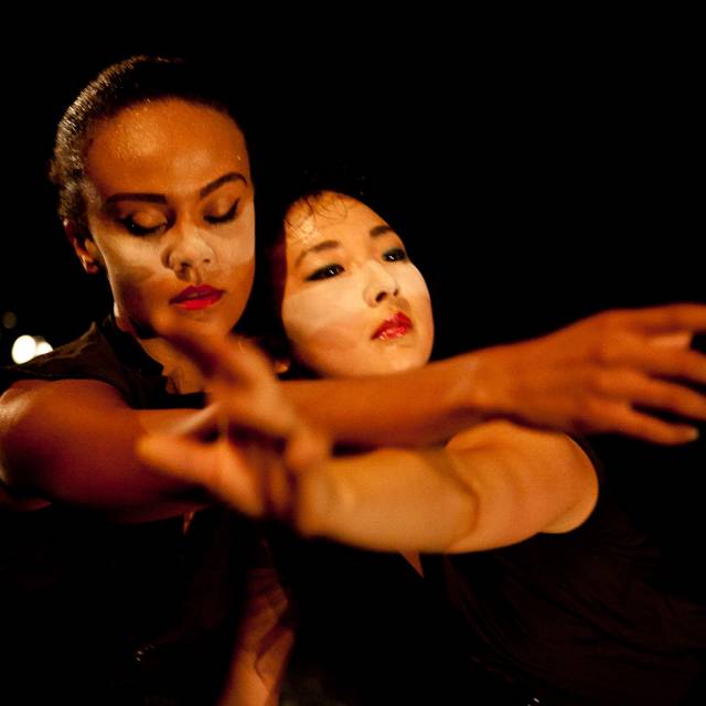 two women cross one of their arms over the other, their heads side by side
