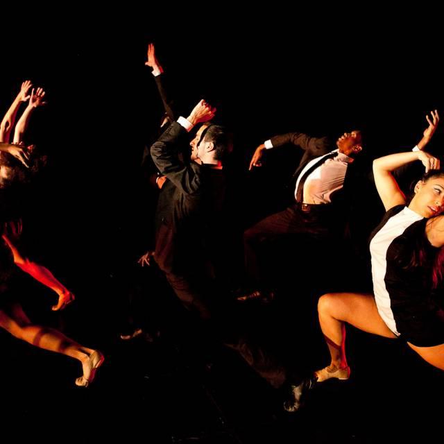 a group of dancers lunge in the same direction