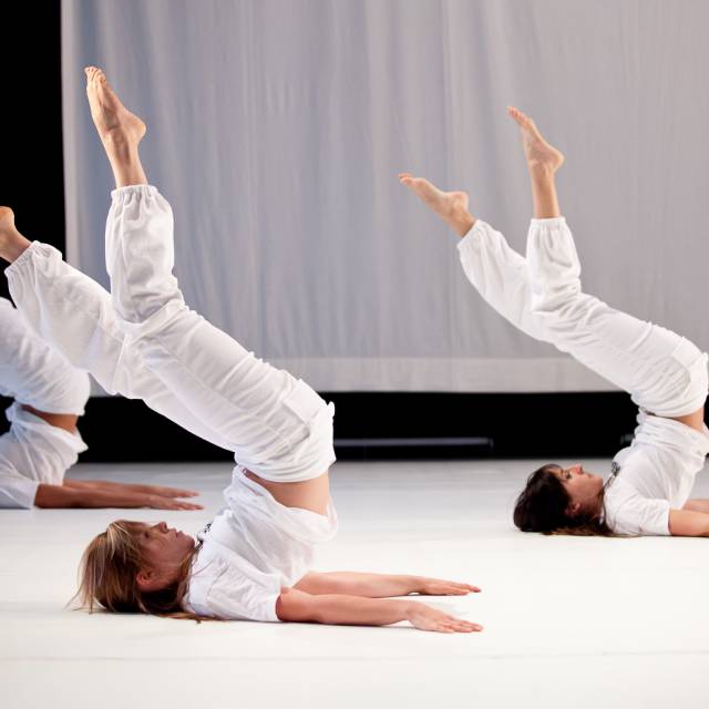 three woman lay on the floor with their legs raised to the sky