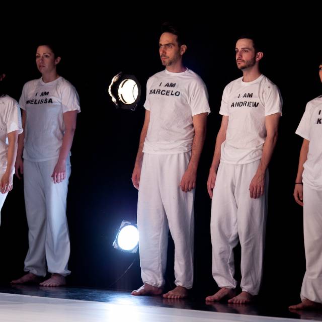 five people stand offstage watching the action