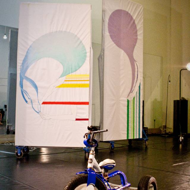 a tricycle positioned in front of two murals