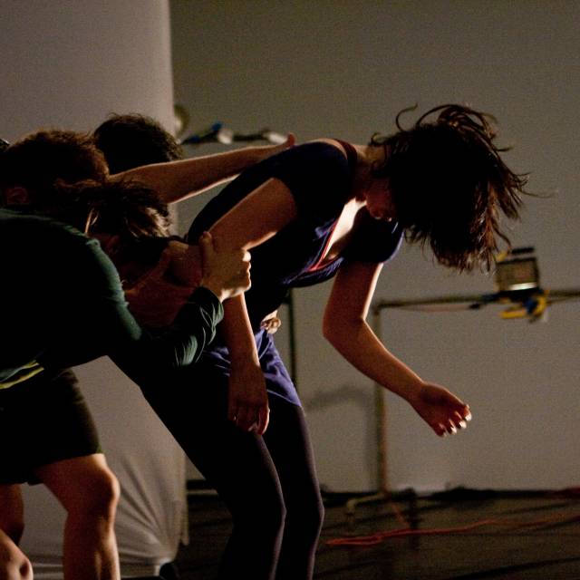several people grab onto the waist and shoulder of a woman
