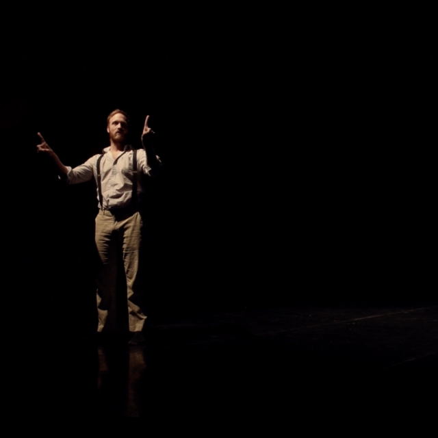 a man stands while pointing his fingers toward opposite sides of his body
