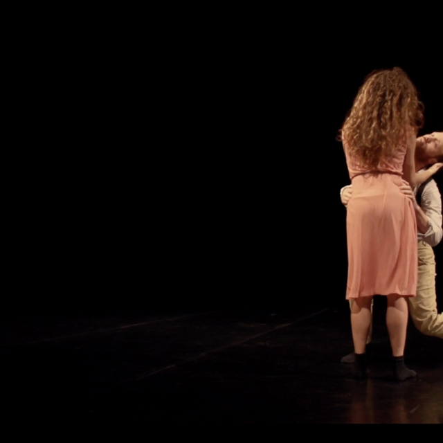 a man bends next to a woman whose back is to us