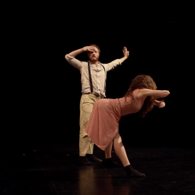 a woman bending over and grabbing the air downstage of a man who has one hand on his forehead and his other arm outstretched 