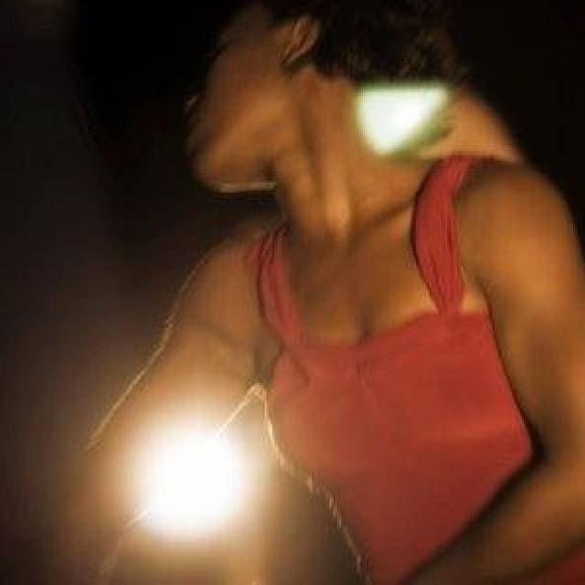 a woman captured in motion & wearing a maroon dress 
