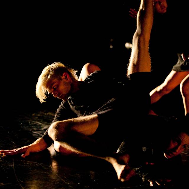a man sits while extending one leg upward