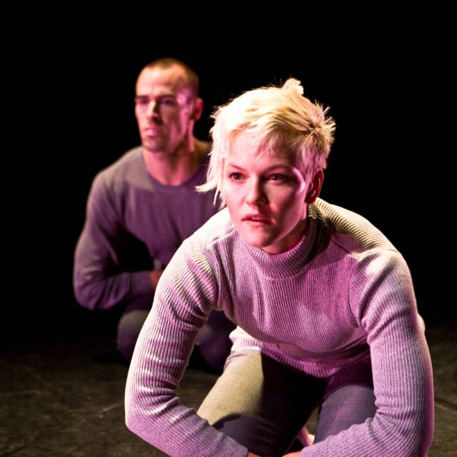 two figures kneel, leaning their torsos forward