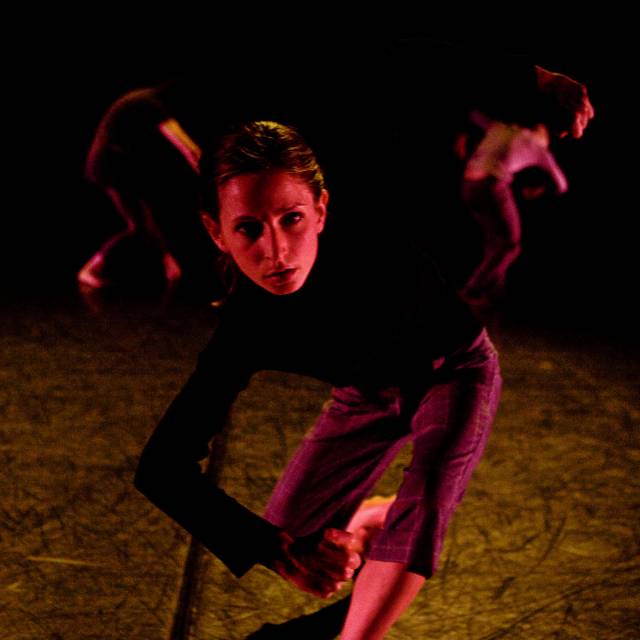 a woman dressed in all black in a contorted position